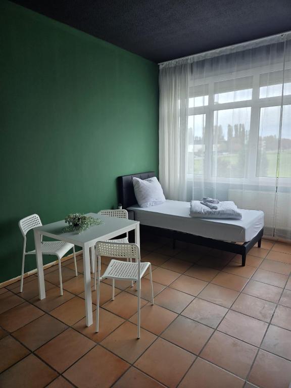 una habitación con una cama, una mesa y sillas en CrownLiving Babylon Studios, en Lustenau