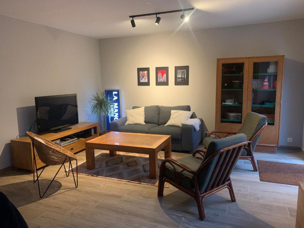 una sala de estar con un sofá y una mesa en La Bisquine, en Granville