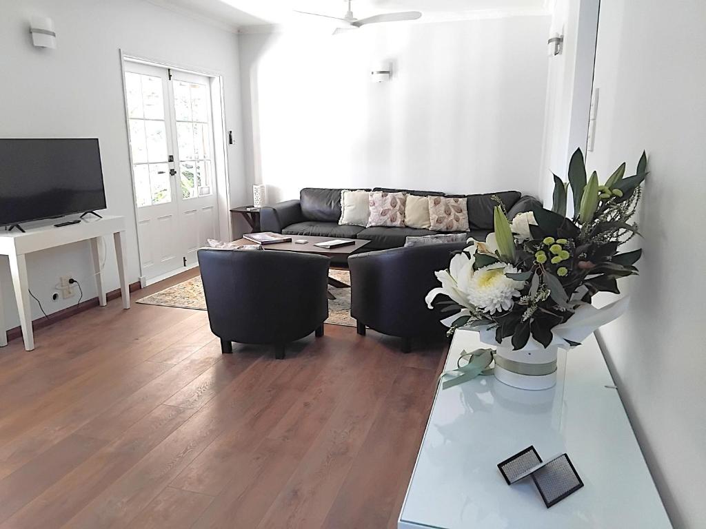 a living room with a couch and a table at Bunya House at On Burgum Pond in Maleny