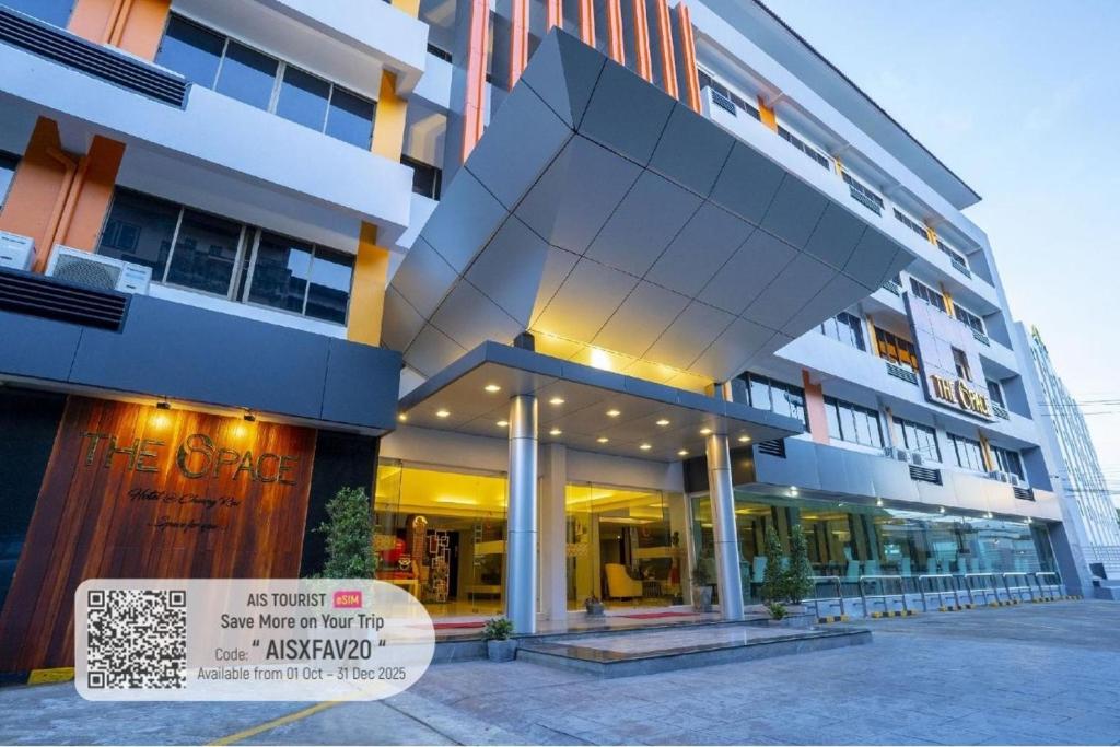a large building with a sign in front of it at The Space Hotel Chiang Rai in Chiang Rai