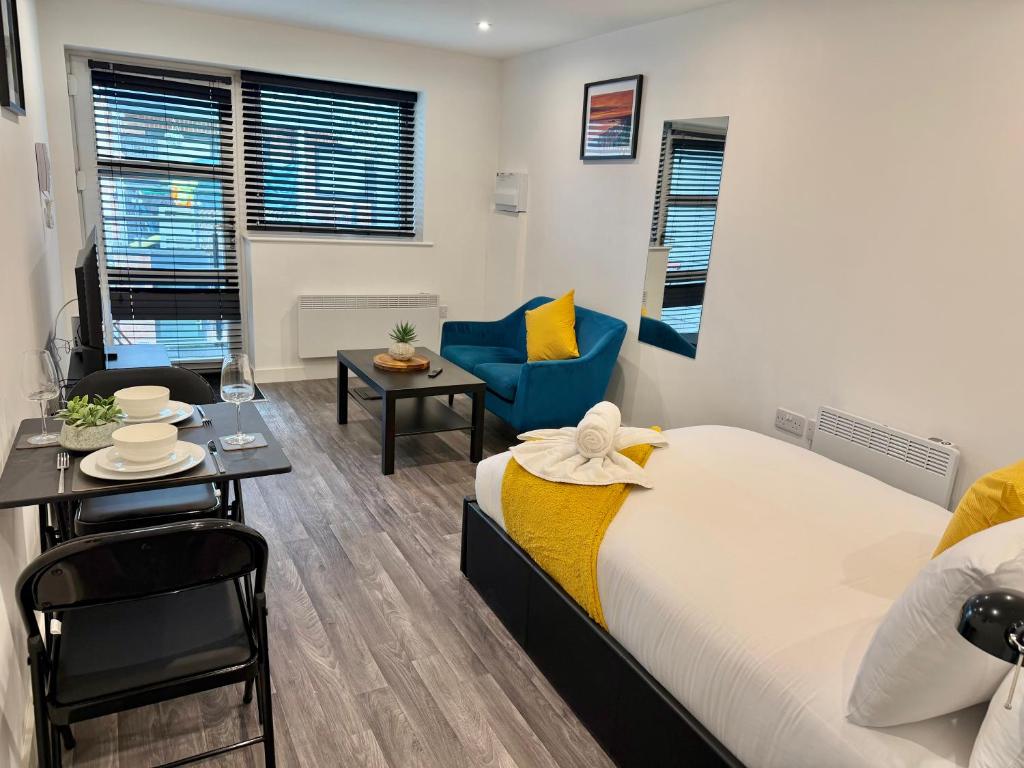 Un dormitorio con una cama y una mesa y sillas. en Seaside Escape - Central Studio Near Beach and Town, en Bournemouth