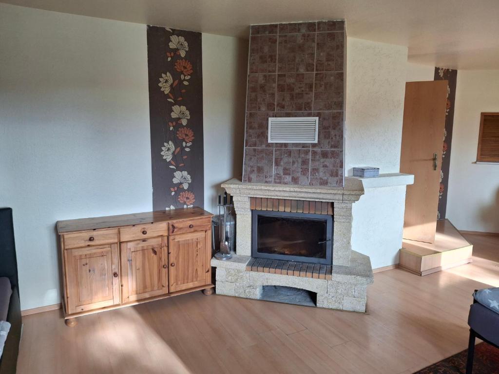a living room with a fireplace and a wooden floor at Gute Laune 3 in Zapel