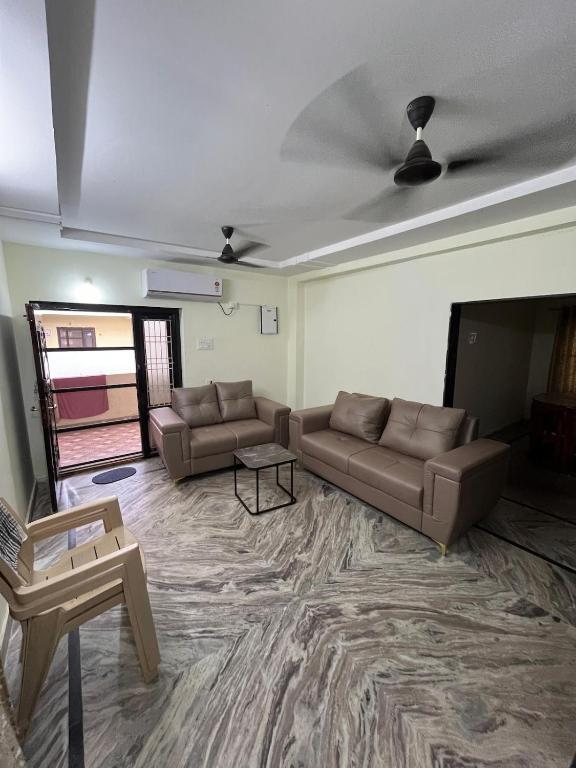 Una sala de estar con sofás y un televisor de pantalla plana. en Happy living 2, en Vijayawada