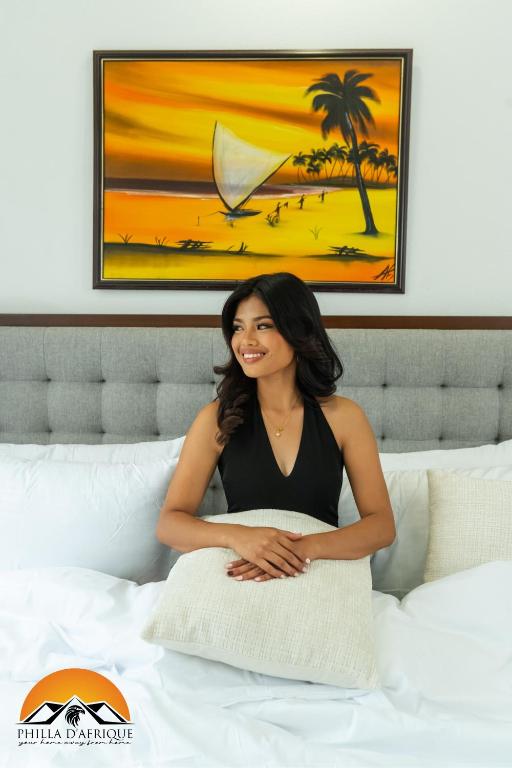 a woman sitting on top of a bed at Philla D Afrique Resort in Inopacan