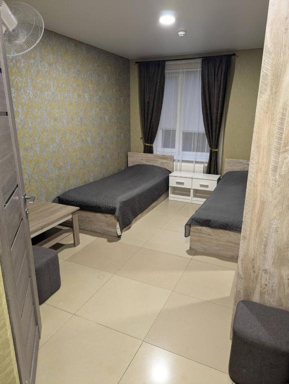 a bedroom with two beds and a window at Villa Maria in Novoarkhanhel's'k