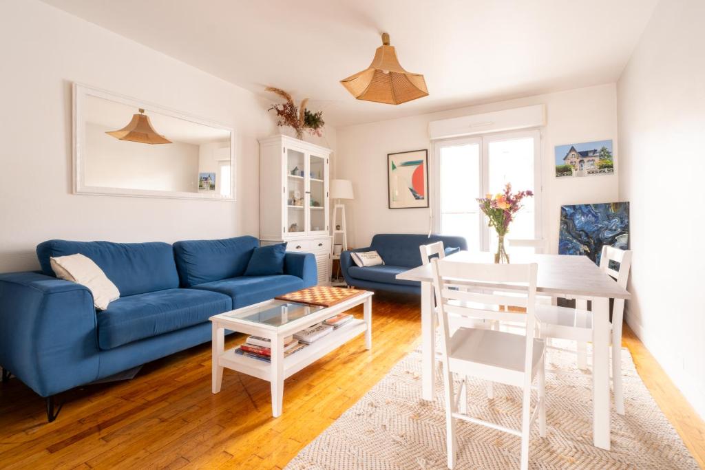 3 chambres lumineux proche gare et TNB في رين: غرفة معيشة مع أريكة زرقاء وطاولة