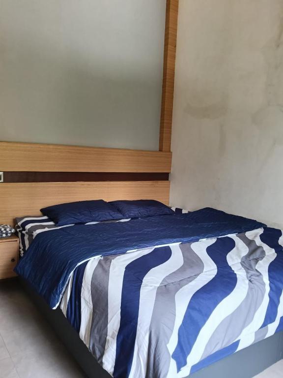 a bed with a blue and white comforter in a bedroom at Savana Guesthouse in Bromo