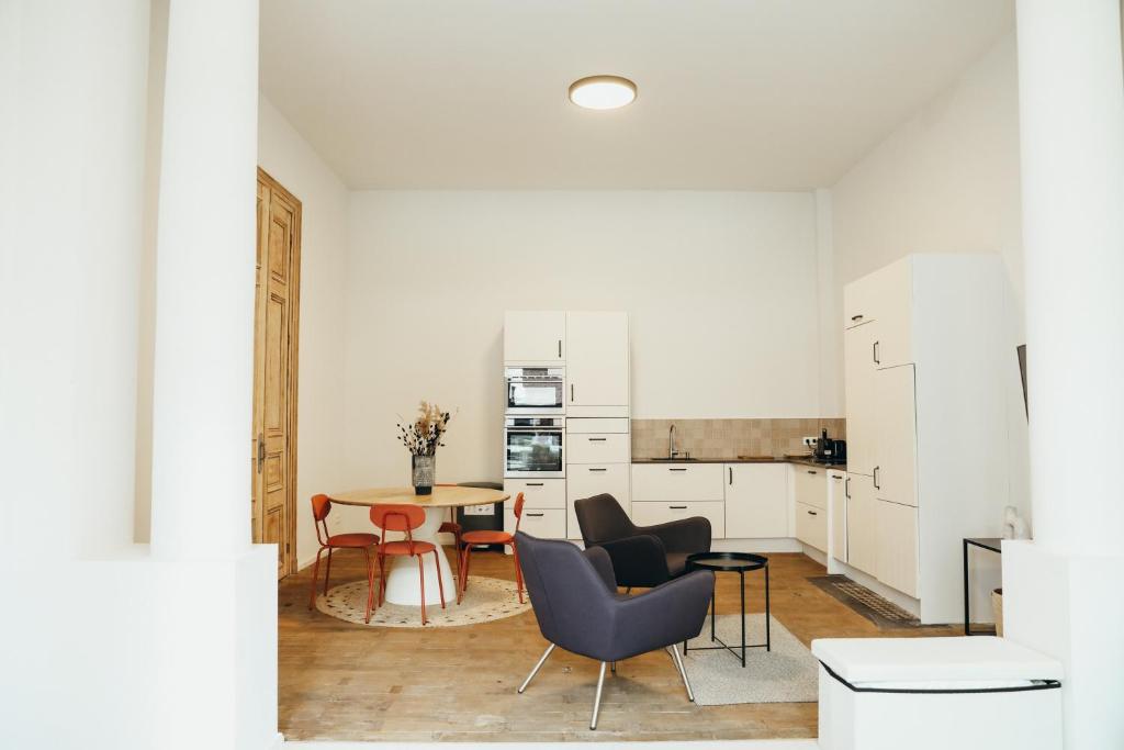 a kitchen and dining room with a table and chairs at La Terrasse des Guillemins by WelcHome in Liège