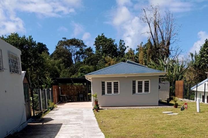 a small white house in a yard at Bungalow Le Petit Havre Pointois in Basse-Pointe