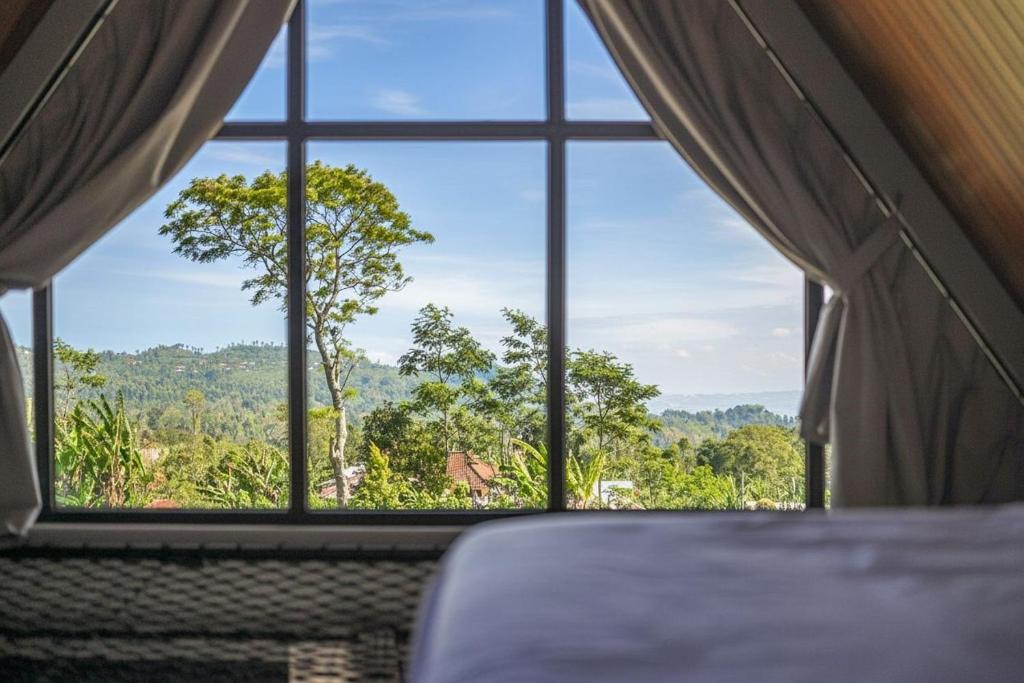 una habitación con una ventana que da a un árbol en Le Nid du Clair de Lune, en Gitgit