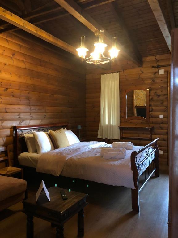 a bedroom with a bed in a log cabin at Panorama Elatis in Elati