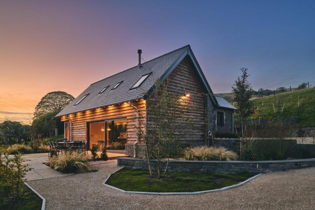 a small wooden house with a gambrel roof at Hay Barn in Trefeglwys