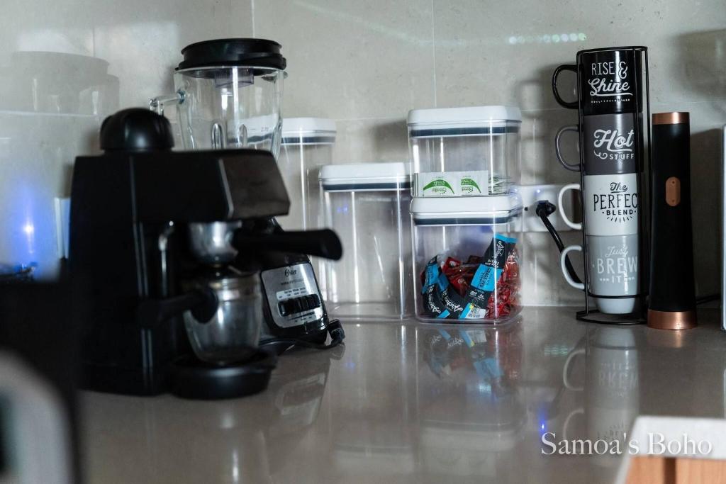 eine Arbeitsplatte mit einer Kaffeemaschine und anderen Artikeln in der Unterkunft Cozy Home in San Juan, Puerto Rico - Perfect for Families in Country Club