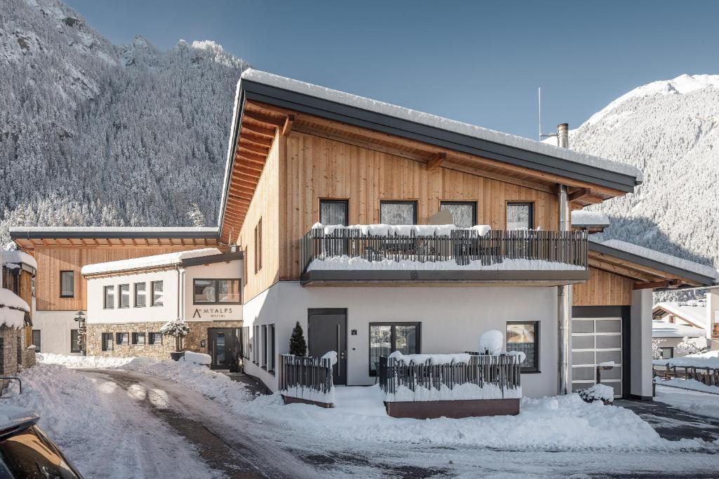 een gebouw met een balkon in de sneeuw bij MYALPS Ötztal inklusive Spa- Area in Umhausen