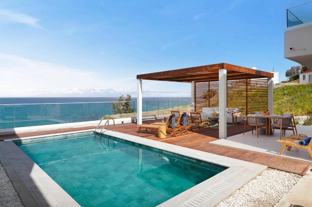 a house with a swimming pool and a gazebo at Villa Astrofegia Moonlit Escape with Sea Views in Pachyammos