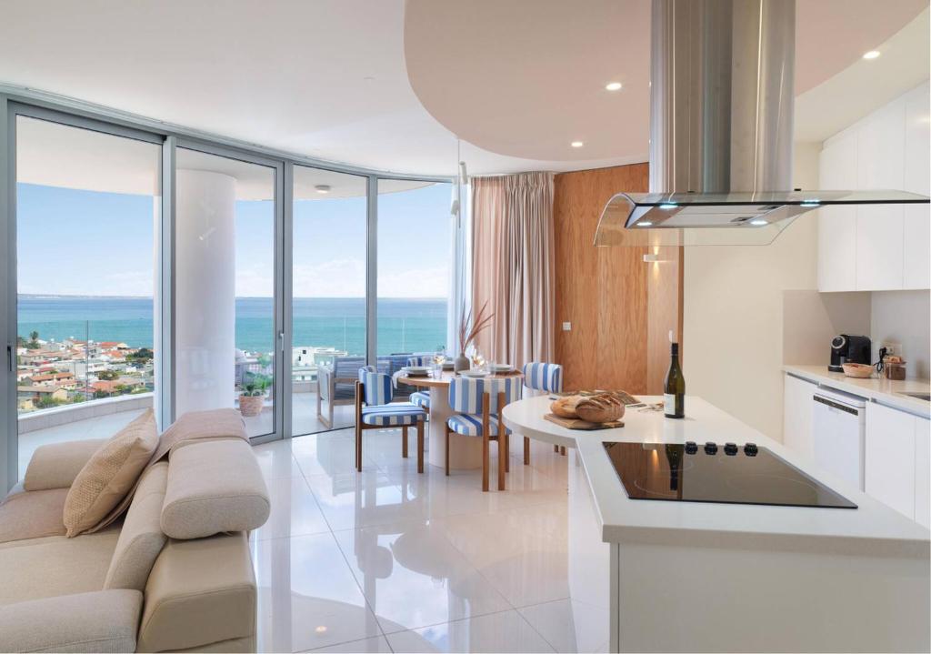 une cuisine et un salon avec un canapé et une table dans l'établissement Suite 1003 at Althea Residence, à Scala