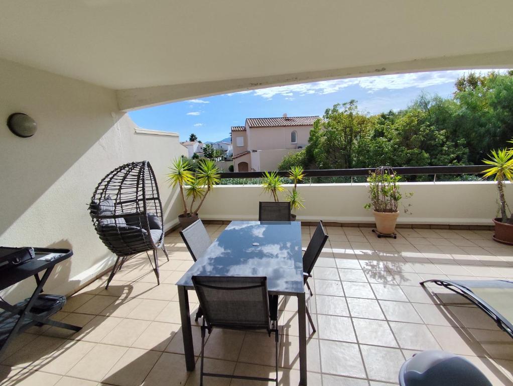 a patio with a table and chairs on a balcony at Résidence L'écume in Saint-Cyprien-Plage
