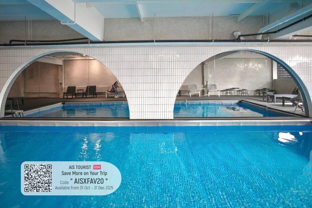 a swimming pool with two arches over the water at E11 Hotel - BTS Punnawithi in Amphoe Phra Khanong