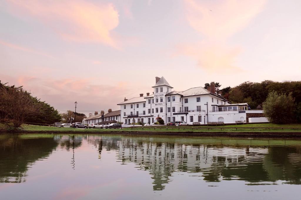 a large white house sitting next to a body of water at The Falcon Hotel in Bude