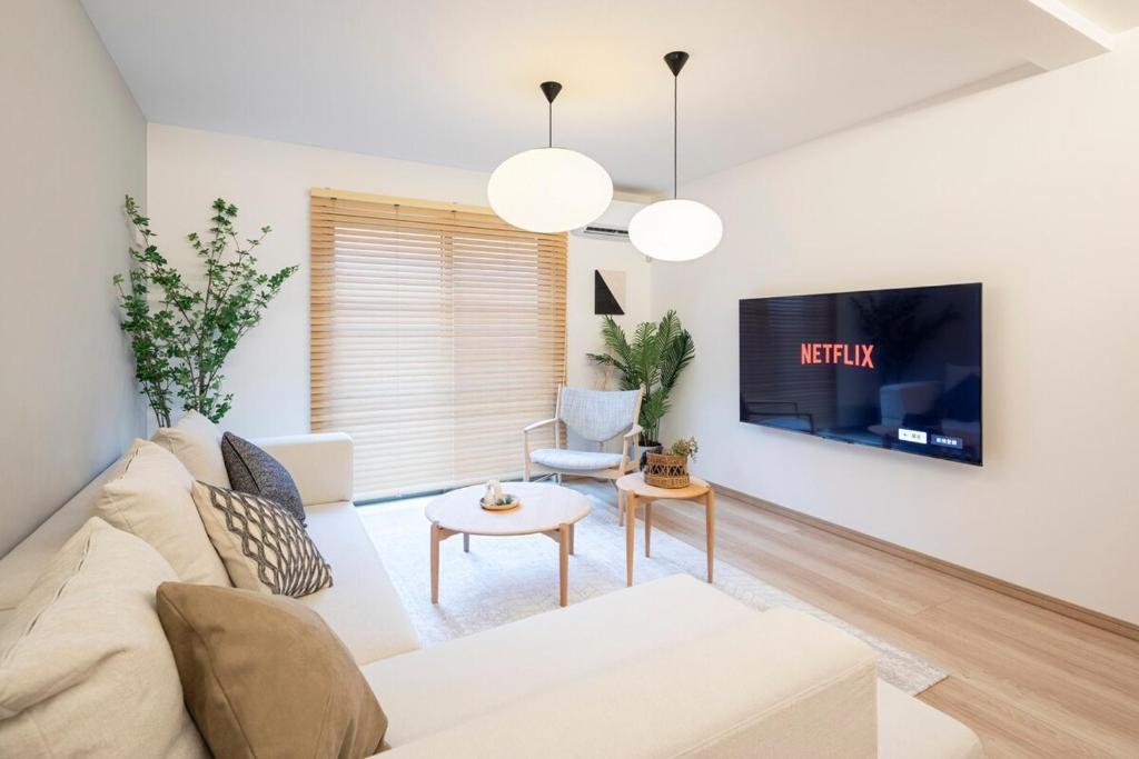 Una sala de estar con un sofá blanco y un televisor. en 和船 wafune, en Tokio