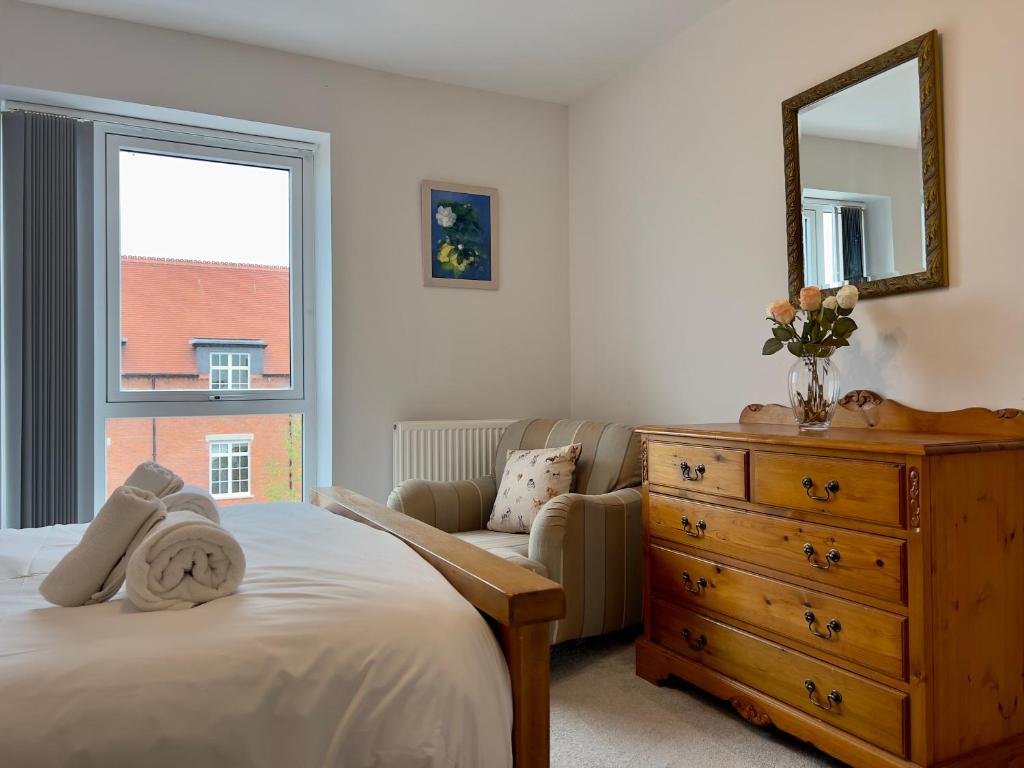 a bedroom with a bed and a dresser and a mirror at Pass the Keys Modern Penthouse Style Apartment in Haddenham in Chearsley