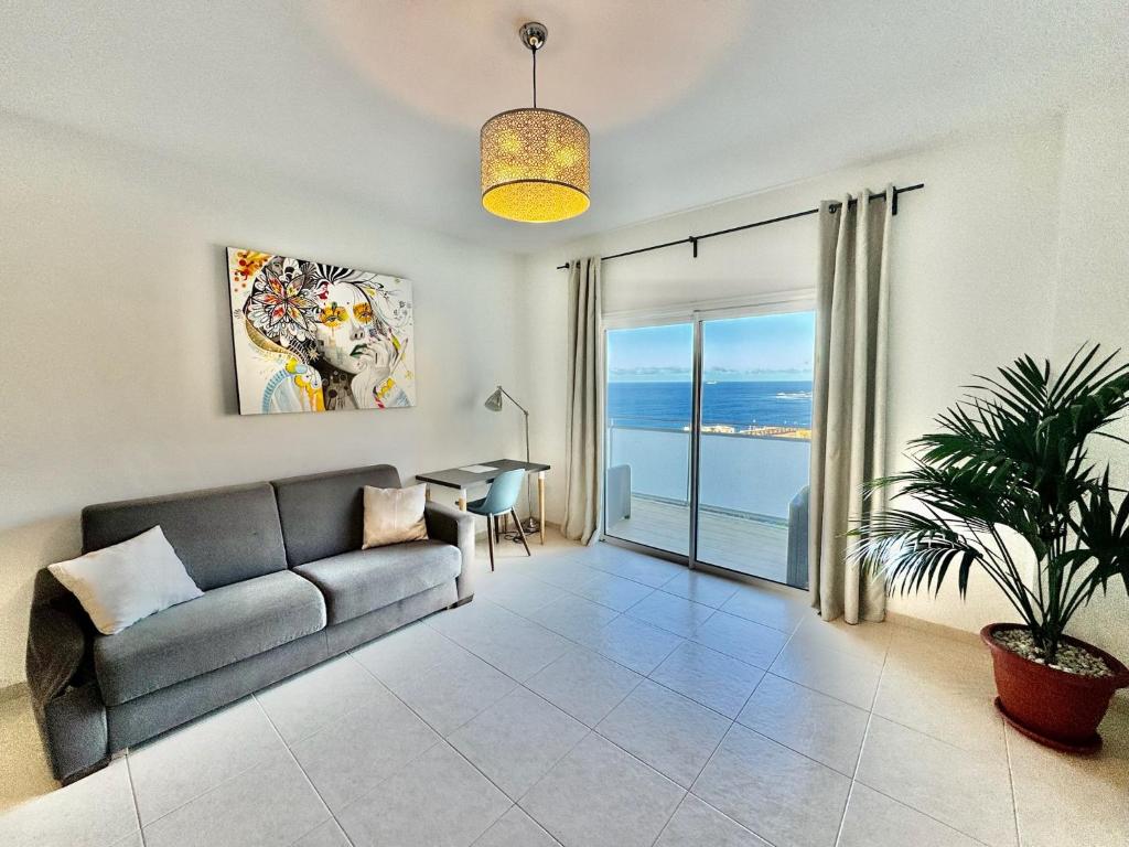 a living room with a couch and a table at El ático Parosa 'con vistas al mar' in Bajamar