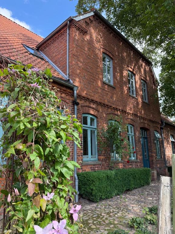 an old brick house with a bush in front of it at Edelhof1877 in Thedinghausen