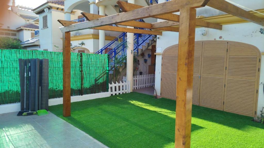 a wooden pergola in front of a house at Residencial Veramar 4, Vera Playa, Almeria in Vera