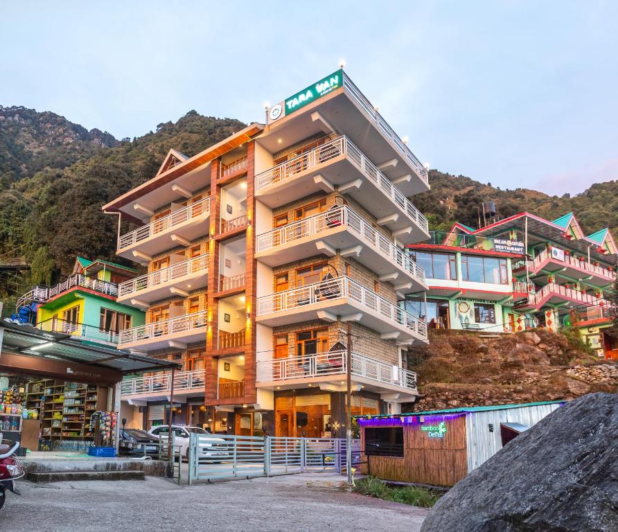 a building with balconies on the side of a mountain at Tara Van in Dharamshala