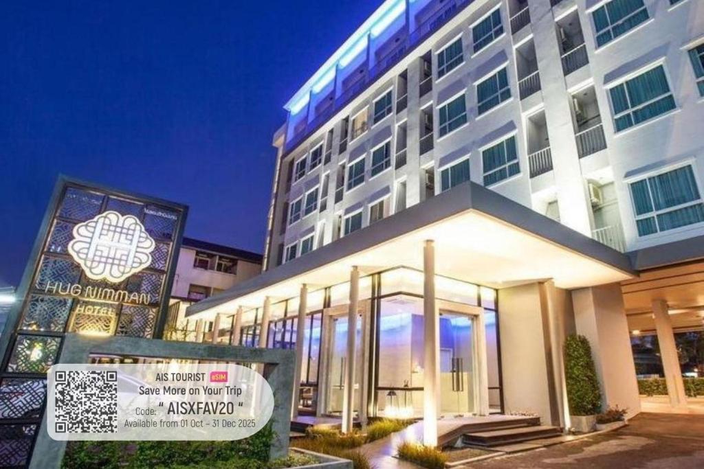 a large building with a sign in front of it at Hug Nimman Hotel in Chiang Mai