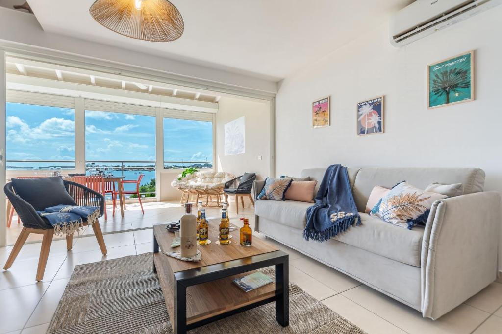 a living room with a couch and a table at Tout est neuf dans ce beau Duplex pour 6 à 7p vue lagon in Marigot