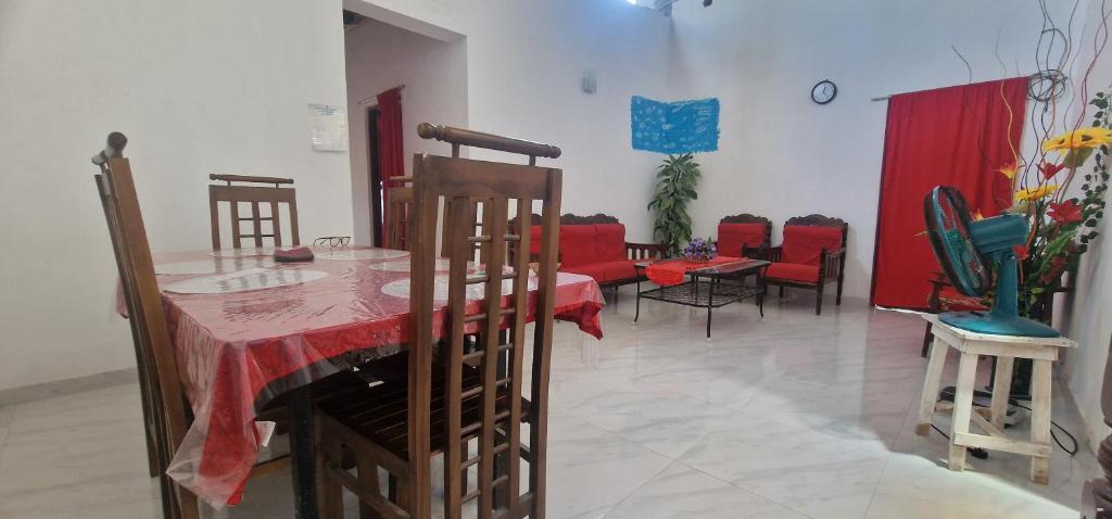 a dining room with a red table and chairs at Perivale Budget Stay in Moratuwa