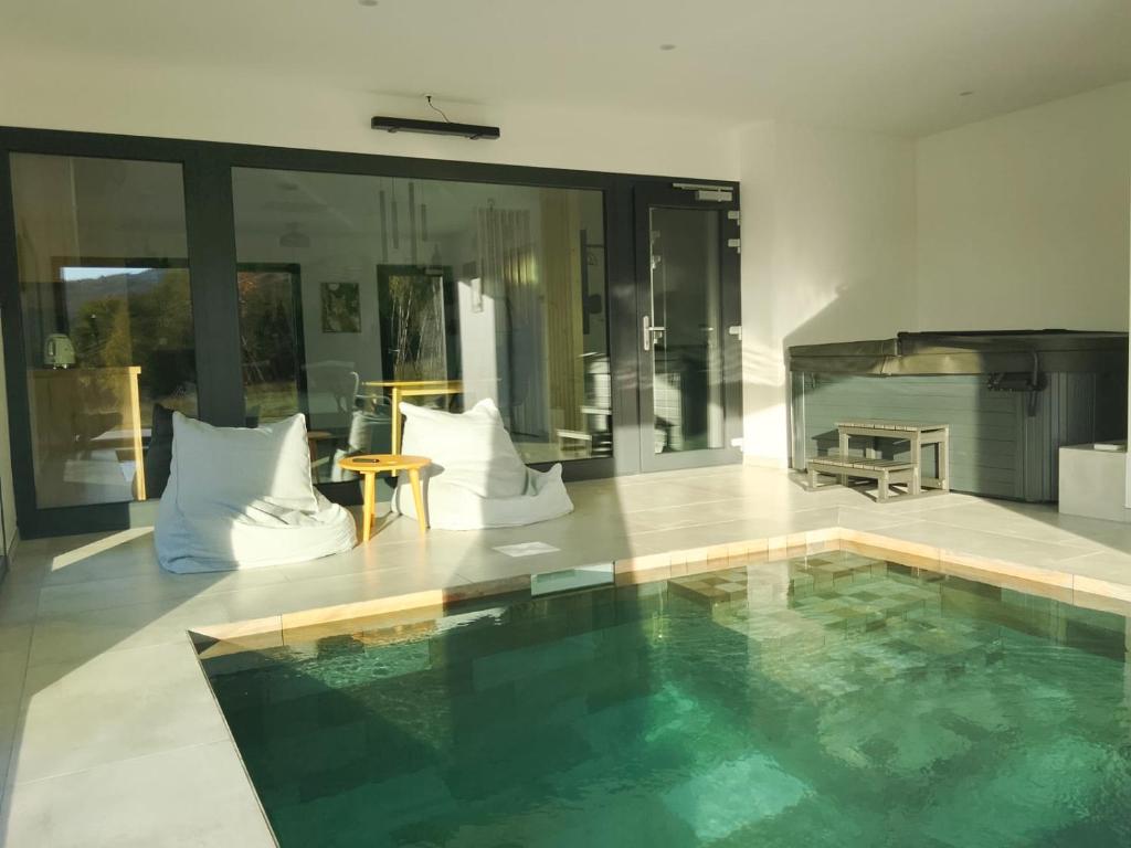 una casa con piscina en una habitación con chimenea en O'Cocoon, en Fraize