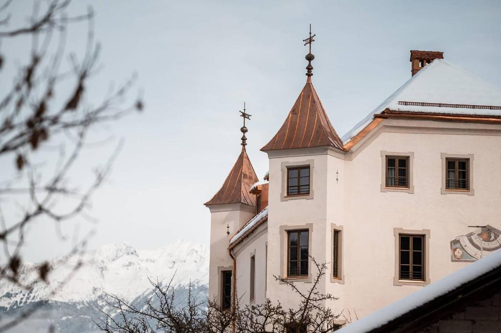 a building with two towers on top of a mountain at Castel Maurn Dolomites in San Lorenzo di Sebato