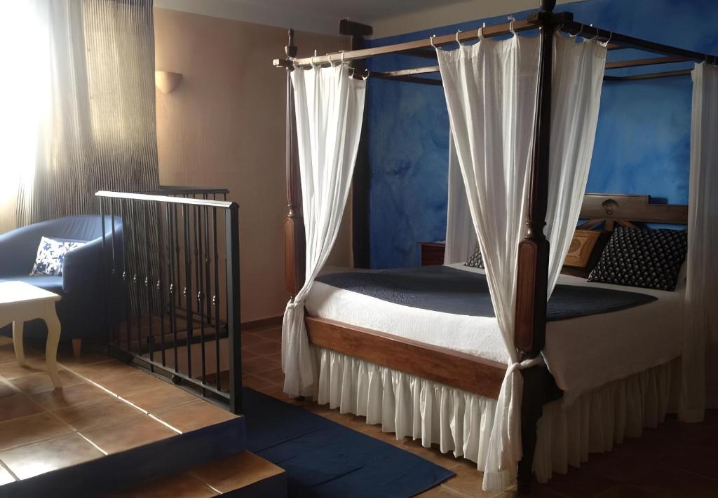 a bedroom with a canopy bed with curtains at Sierra Quilama in San Miguel de Valero
