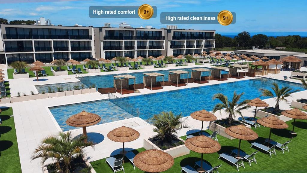 an aerial view of a hotel with a pool with umbrellas at Resort Del Mar Emotion in Pula