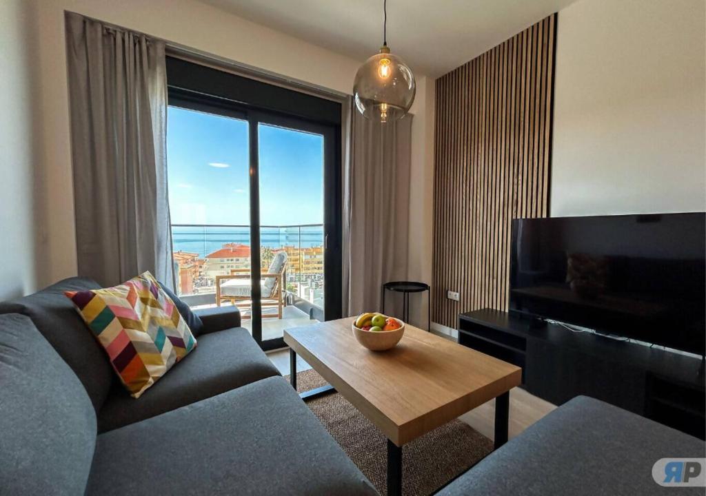 a living room with a couch and a table and a large window at 007 Apartamento con vistas al mar in Algarrobo-Costa