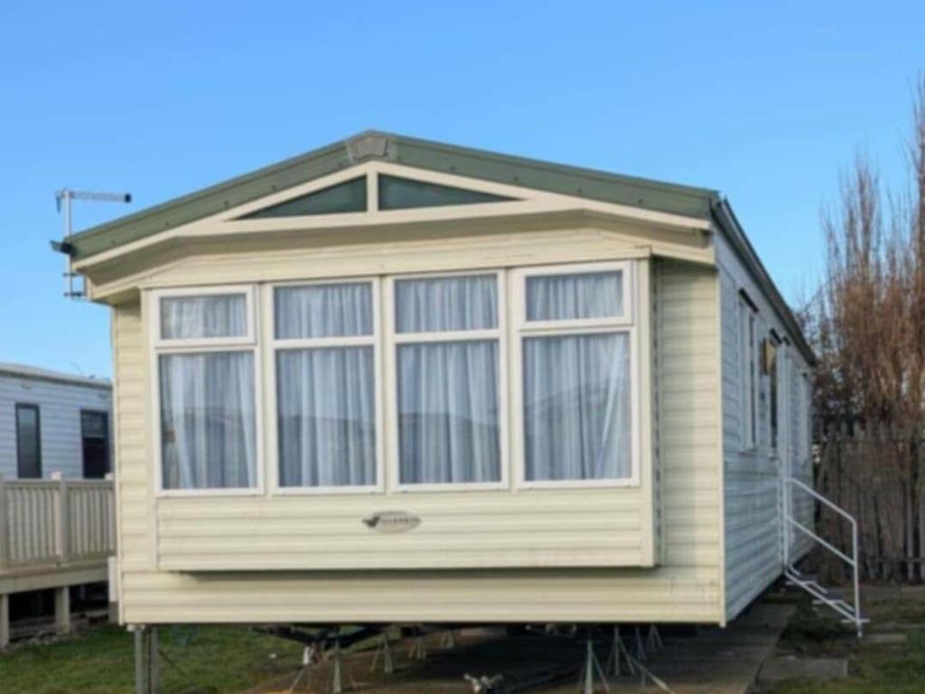 a small house with a large window on a yard at Camber Sands Holiday Park - Holiday Accommodation 21210 in Camber