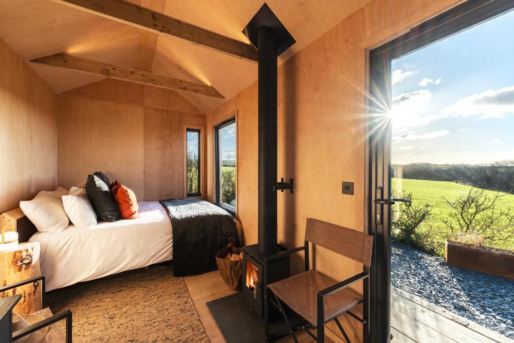 a bedroom with a bed and a fireplace at Cabins at Bogee Farm in Saint Ervan