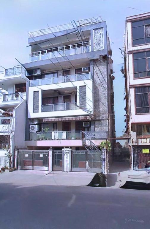 a tall white building with a staircase in front of it at Cassava Stay - Near Rajendra Place & BLK Hospital in New Delhi