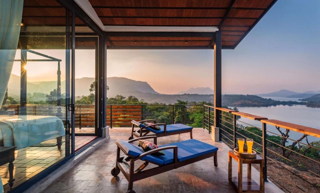 um quarto com vista para a água e para as montanhas em SaffronStays Satori Perch Regal - 4BR Tuscan-style villa with pool, farm meals & 270 Degree Mulshi Lake views near Pune em Mulshi