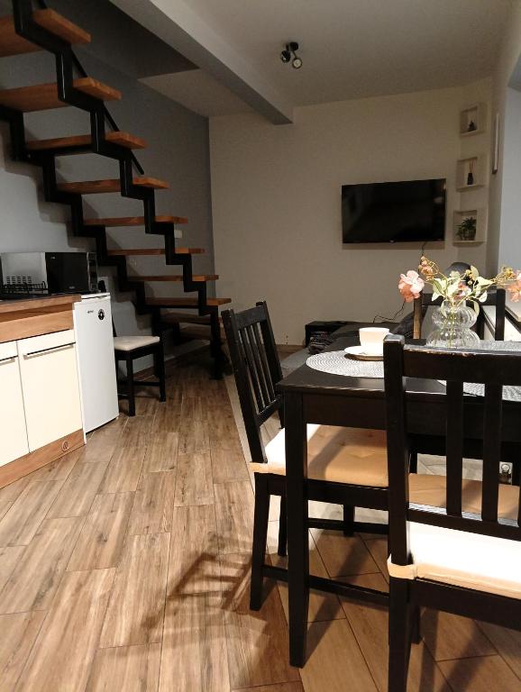 - un salon avec une table, des chaises et des escaliers dans l'établissement Apartament dwupoziomowy Dom na patio Kościuszki self-check-in, à Katowice