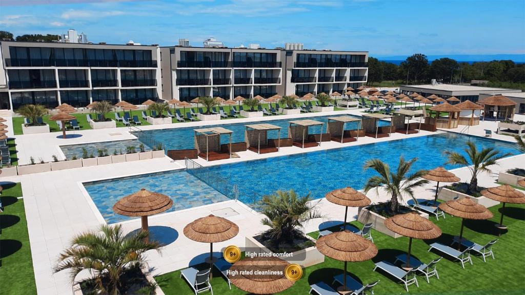 an aerial view of a hotel with a pool with umbrellas at Resort Del Mar Emotion in Pula