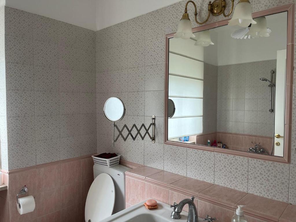 a bathroom with a sink and a toilet and a mirror at appartamentoviaguedoz in Aosta