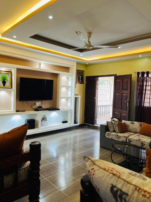 uma sala de estar com um sofá e uma TV de tela plana em 3 Bedroom Own Compound em Melinde