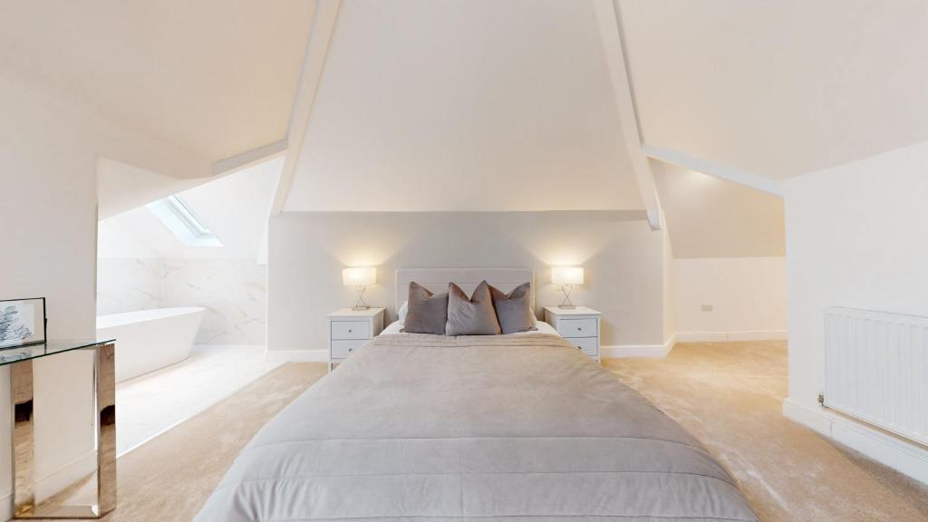 ein weißes Schlafzimmer mit einem großen Bett und einer Badewanne in der Unterkunft Luxury Penthouse Duplex in Newport