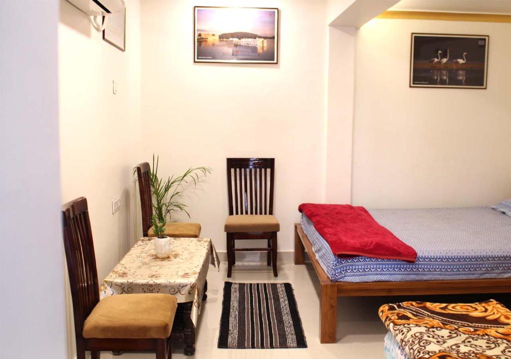 a bedroom with a bed and a table and chairs at Pink City Heritage Homestay in Jaipur