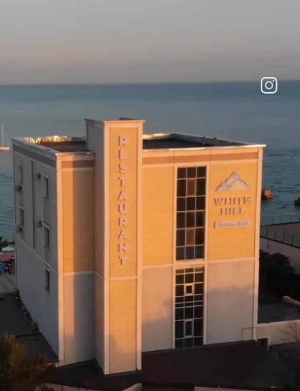 a building with the ocean in the background at Boutique Hotel "White HiLL" in Aktau