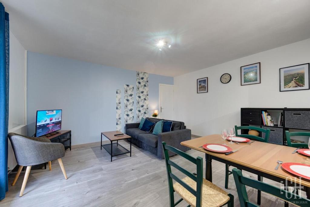 Una sala de estar con una mesa y una sala de estar con un sofá. en Appartement hyper centre - Parking - 2v, en Tours
