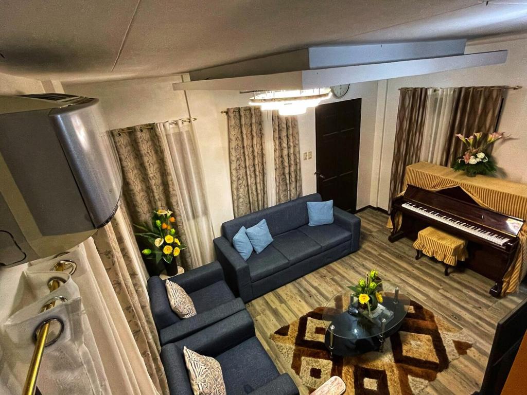 Una sala de estar con un sofá y un piano. en Breezynest in Island Front -by Darysen, en Alaminos